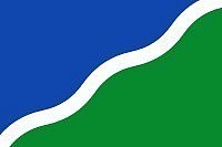 Drapeau de Lasne 30/04/1999  Symbolisme : La couleur bleue symbolise le ciel, le vert représente l'environnement naturel de la commune. La ligne ondulée blanche symbolise la rivière Lasne.